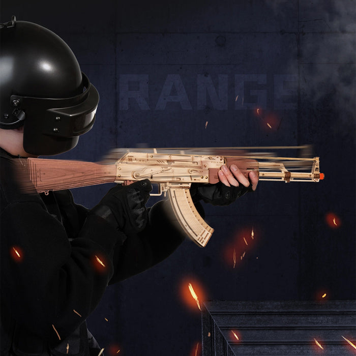 ROKR AK-47 Assault Rifle Toy Gun LQ901 3D wooden puzzle lifestyle, person in military gear aiming the assembled natural wood AK-47 model at a range with sparks in the background