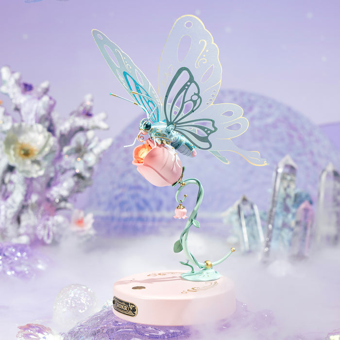 ROKR Butterfly 3D mechanical puzzle in mint and pink shades posed among crystal formations with a soft purple fantasy