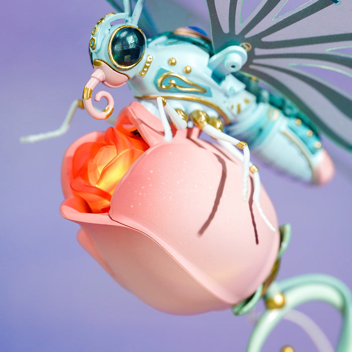 ROKR Butterfly 3D puzzle close-up showing the mint green mechanical body gripping a glowing pink peony bud with gold accents