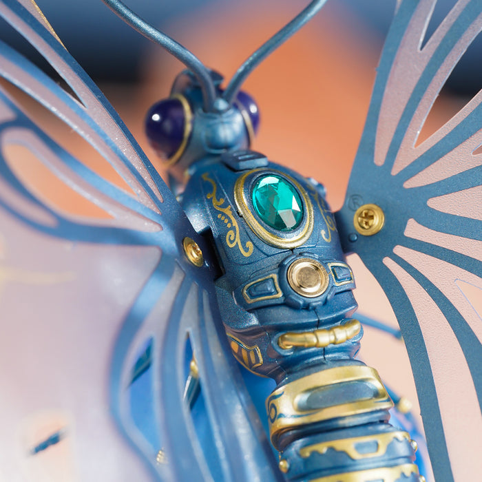 ROKR Butterfly mechanical puzzle close-up of the blue and gold body with a green gem eye detail and purple orb antennae