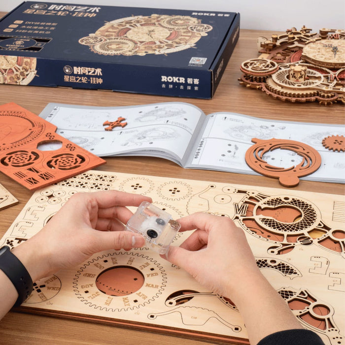 ROKR Zodiac Wall Clock 3D wooden puzzle LC601 fully assembled showing the circular gear-driven face with zodiac symbols hanging on a blue-grey wall beside a white marble bust