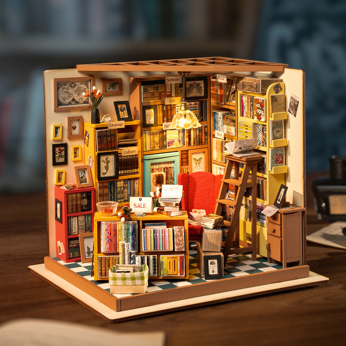 Rolife Sam's Study Library DG102 DIY miniature house with open roof showing the turquoise door, red reading chair, sale display table and bookshelf-lined walls