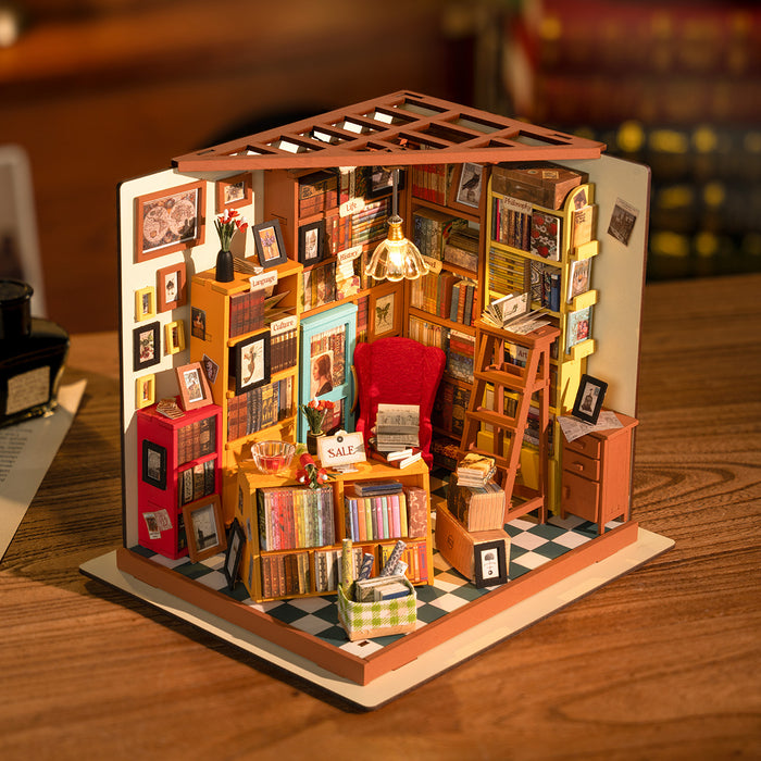Rolife Sam's Study Library DG102 miniature bookshop displayed at three-quarter angle showing warm LED lighting, red ladder, framed art and colorful stacked books